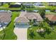 Aerial view of a well-maintained home with an attached two car garage, lush landscaping, and waterfront access at 233 Fairway Rd, Rotonda West, FL 33947