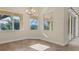 Sunlit dining area with chandelier, tile flooring, and large windows offering serene outdoor views at 233 Fairway Rd, Rotonda West, FL 33947