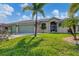 Charming home with a well-manicured front lawn, mature palm trees, and a spacious two-car garage at 233 Fairway Rd, Rotonda West, FL 33947