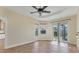 Bright living room with tile floors, ceiling fan, and access to the outdoor patio at 233 Fairway Rd, Rotonda West, FL 33947