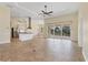 Spacious living room with tile floors, open floor plan, modern ceiling fan, and sliding glass doors to the lanai at 233 Fairway Rd, Rotonda West, FL 33947
