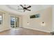 Well-lit living room features neutral walls, tile floors, a ceiling fan, and a sliding glass door at 233 Fairway Rd, Rotonda West, FL 33947