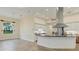 Open living space with kitchen island, stainless appliances, and large windows offering natural light and views at 233 Fairway Rd, Rotonda West, FL 33947