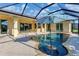 Spacious screened-in pool with built-in table and sun umbrella, with ample deck space at 233 Fairway Rd, Rotonda West, FL 33947