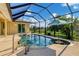 Backyard screened-in pool with sun umbrella and built-in table, perfect for relaxing at 233 Fairway Rd, Rotonda West, FL 33947