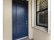 Modern navy blue front door with updated hardware and side window at 10385 Crooked Creek Dr, Venice, FL 34293