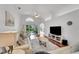 Spacious living room with hardwood floors, neutral furniture, and a large TV at 1188 Harbor Town Way, Venice, FL 34292