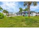 Large grassy backyard with patio, seating area, and palm tree at 8509 La Boca Ave, North Port, FL 34287