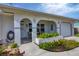 Inviting front porch with arched entryway, well-manicured landscaping, and a two-car garage at 8509 La Boca Ave, North Port, FL 34287