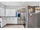 Updated kitchen featuring stainless steel refrigerator and white shaker cabinets at 8509 La Boca Ave, North Port, FL 34287