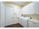 Bright laundry room with washer, dryer, and additional storage at 4376 Corso Venetia Blvd, Venice, FL 34293