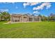 Large backyard featuring a screened pool area and green lawn at 4376 Corso Venetia Blvd, Venice, FL 34293