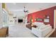 Spacious living room with white sofas, a large TV, and a red accent wall at 4376 Corso Venetia Blvd, Venice, FL 34293