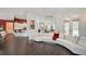 Open floor plan with large curved sectional sofa, hardwood floors, and kitchen at 4376 Corso Venetia Blvd, Venice, FL 34293