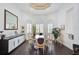Bright dining room with round table and chairs, hardwood floors, and large mirror at 4376 Corso Venetia Blvd, Venice, FL 34293