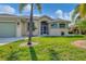 Single Gathering house exterior with green garage door at 233 Fairway Rd, Rotonda West, FL 33947