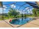 Relaxing kidney-shaped pool with screened enclosure and backyard view at 233 Fairway Rd, Rotonda West, FL 33947