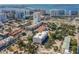 Aerial view of a modern building near the water, surrounded by other buildings and lush trees at 332 Cocoanut Ave # 503, Sarasota, FL 34236