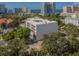Aerial view of a modern building near the water, surrounded by other buildings and lush trees at 332 Cocoanut Ave # 503, Sarasota, FL 34236