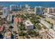 Aerial view of a modern building near the water, surrounded by other buildings and lush trees at 332 Cocoanut Ave # 503, Sarasota, FL 34236