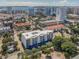 Aerial view of a modern building near the water, surrounded by other buildings and lush trees at 332 Cocoanut Ave # 503, Sarasota, FL 34236