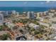 Aerial view of a modern building near the water, surrounded by other buildings and lush trees at 332 Cocoanut Ave # 503, Sarasota, FL 34236