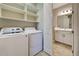 Laundry room with washer, dryer, and ample shelving at 380 Casalino Dr, Nokomis, FL 34275