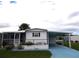 White single-wide manufactured home with carport and landscaped yard at 427 Boxwood Dr, Venice, FL 34285