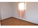 Simple bedroom with wood-look flooring and a window with peach curtains at 427 Boxwood Dr, Venice, FL 34285