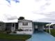 Front view of a white manufactured home with carport and landscaping at 427 Boxwood Dr, Venice, FL 34285