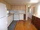 Small kitchen with white cabinets, stove, refrigerator, and wood-look floors at 427 Boxwood Dr, Venice, FL 34285