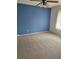 Cozy carpeted bedroom with a bright blue accent wall and a modern ceiling fan at 4619 Flint Dr, North Port, FL 34286