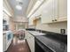 Well-lit kitchen with white cabinets and black countertops overlooking breakfast nook at 4619 Flint Dr, North Port, FL 34286