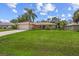 Tan house with a large yard and palm trees at 4619 Flint Dr, North Port, FL 34286