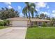 House exterior showcasing a tan facade and a palm tree at 4619 Flint Dr, North Port, FL 34286