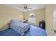Bedroom with blue carpet, ceiling fan, and arched window at 4619 Flint Dr, North Port, FL 34286