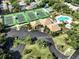 Aerial view of community clubhouse, pool, and tennis courts at 600 Carriage House Ln # 104, Nokomis, FL 34275