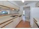 Kitchen with white cabinets and double sink overlooking entryway at 600 Carriage House Ln # 104, Nokomis, FL 34275