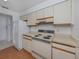 Kitchen features white cabinets, electric stove, and refrigerator at 600 Carriage House Ln # 104, Nokomis, FL 34275