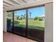 View of the backyard and lake through sliding glass doors at 600 Carriage House Ln # 104, Nokomis, FL 34275