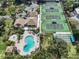 Aerial view of community pool, tennis courts, and clubhouse at 600 Carriage House Ln # 104, Nokomis, FL 34275