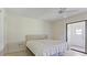 Well-lit bedroom featuring a fan, with sliding doors and outside access to an enclosed patio at 8 Quails Run Blvd # 6, Englewood, FL 34223