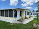Front view of the yellow mobile home with landscaping and walkway at 406 Trento, Venice, FL 34285