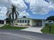 Yellow single-wide mobile home with carport and landscaping at 406 Trento, Venice, FL 34285