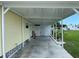 Covered carport area adjacent to the mobile home, providing shade and parking at 406 Trento, Venice, FL 34285