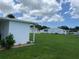 View of backyard with green lawn and neighboring homes at 406 Trento, Venice, FL 34285