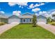 Two-unit building with light blue exterior, attached garages, and landscaping at 2129 Royal Tern Cir, Punta Gorda, FL 33983