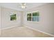 Spacious bedroom with two windows, ceiling fan, and carpeted floor at 2143 Starlite Ln, Port Charlotte, FL 33952