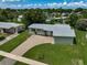 Aerial view of a single-Gathering home with a driveway and well-maintained lawn at 2143 Starlite Ln, Port Charlotte, FL 33952
