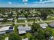 Aerial view of a residential area, featuring houses with green lawns and tree cover at 2143 Starlite Ln, Port Charlotte, FL 33952